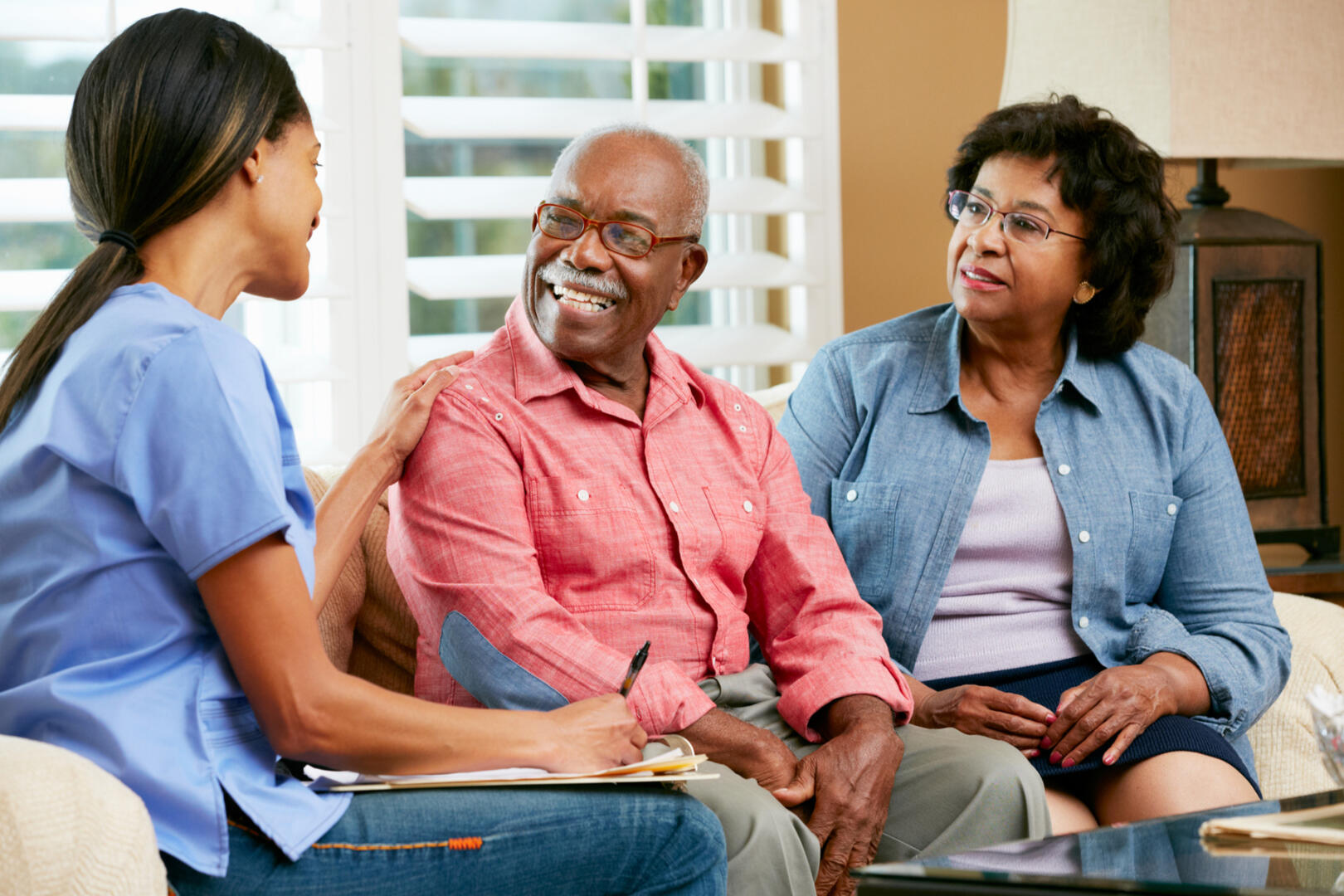 Picture of young black lady completing an assessment with elder black couple.